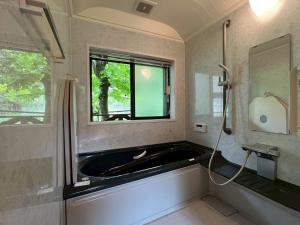 a bathroom with a bath tub and a window at Okutama Guesthouse - Vacation STAY 45619v in Hikawa +12 photos