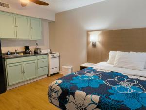 a bedroom with a bed and a kitchen with a sink at Sand Dollar Motel in Atlantic Beach
