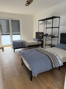 a room with three beds and a room with windows at Luxus Appartement- Waldheim in Rote Warte +11 photos