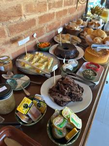 ein Tisch voller verschiedener Kuchen und Gebäcksorten in der Unterkunft Cabanas Zig Zag in Santo Antônio do Pinhal