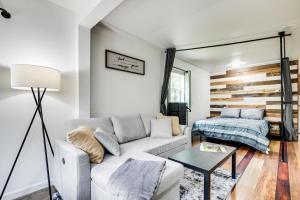 una sala de estar con un sofá y una cama en Woodsy and Charming! Tiny Cottage with Yard in Pelkie, en White