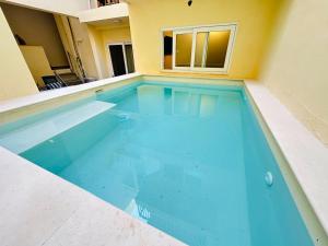 a swimming pool with blue water in a building at Gozo Vacation Studios in Nadur