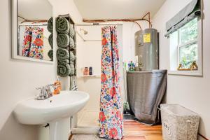un baño con lavabo y ducha en Woodsy and Charming! Tiny Cottage with Yard in Pelkie, en White