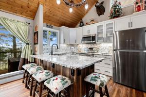 eine Küche mit weißen Schränken und eine große Insel mit Barhockern in der Unterkunft Eagles Court 42 With Wintergreen Advantage in Roseland