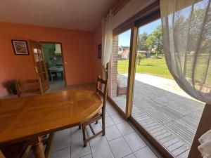 una sala da pranzo con tavolo in legno e porta scorrevole in vetro di La Maison des Oiseaux Résidence Pernes en Artois a Pernes