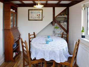a dining room table with a white table cloth at Apple Tree Cottage in Charmouth