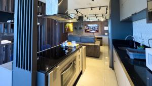 a kitchen with a sink and a living room at 23 Andar no Vertigo Premium com Vista Espetacular in Campo Grande +2 photos