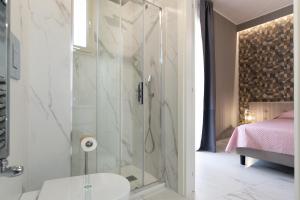 a bathroom with a shower with a toilet and a bed at Domus Suite in Termoli +44 photos