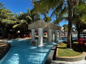 a swimming pool with a gazebo and palm trees at Lacqua Di Roma 12345 Caldas Novas in Caldas Novas