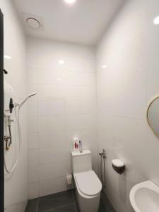 a white bathroom with a toilet and a sink at Soga Homestay 6 Rooms 4 Baths New House in Batu Pahat