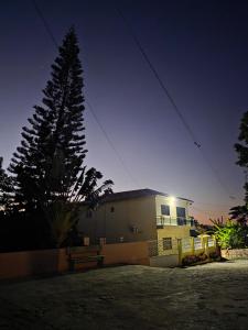 a house with a tree in front of it at night at Chácara Duquinha 3 in Triunfo +3 photos