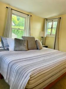 a bedroom with a large bed with two windows at The Lookout - Spacious Apartment in Superb Location in Burlington +1 photo