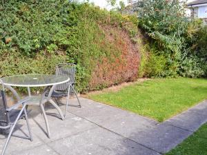 a table and chairs sitting next to a yard at Beach Walk Cottage in Scarborough