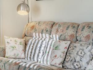 a couch with pillows on it in a living room at Rose Cottage in Pembrey