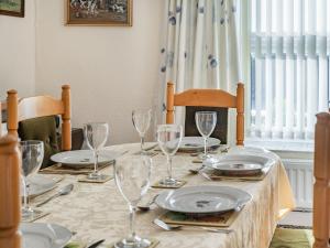 a table with plates and wine glasses on it at Rose Cottage in Pembrey