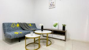 a living room with a blue couch and two tables at BaySuites KK city homestay in Kota Kinabalu