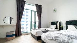 a bedroom with two beds and a large window at BaySuites KK city homestay in Kota Kinabalu