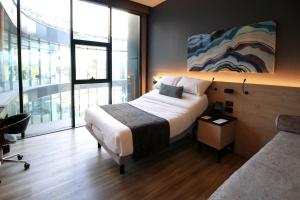 a bedroom with a bed and a couch and windows at Quartz Care Hotel & Spa Tijuana in Tijuana +41 photos