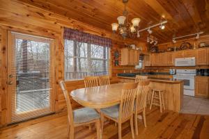 a dining room with a wooden table and chairs at HIckernut Lodge by American Patriot Getaways in Walnut Grove