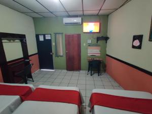 una habitación con 2 camas y una mesa en una habitación en HOTEL LATlNO en Santa Ana, en Santa Ana 32 fotos más