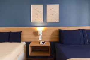 a hotel room with two beds and a table with a lamp at BOOK A FLAT Jardins São Paulo in São Paulo