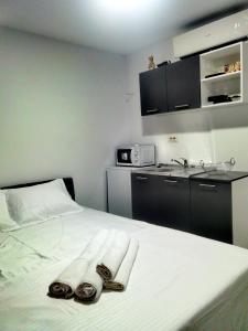 a bedroom with a bed with two towels and a sink at Studio Olimp Sea View Apartments in Olimp +9 photos