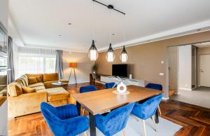 パルヌにあるPrivate holiday home near Pärnu and Lottemaaのリビングルーム(木製テーブル、青い椅子付)