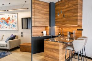 OlsztynにあるOmega Lake Premium Apartmentsのカウンターとスツール付きのバーのあるキッチン