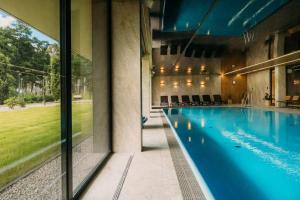 OlsztynにあるOmega Lake Premium Apartmentsの大きな窓のある建物内のプール