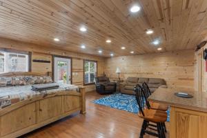 a log cabin bedroom with a bed and a desk at Mr Hills Mercantile Cabin with a hot tub in Bryant +27 photos
