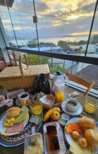 a table with breakfast foods and a view of the ocean at Casa da Flor Guest House – Praia Grande – Beto Carrero in Penha +60 photos