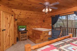 a bedroom with a bed and a tv in a cabin at Hidden Pleasure by American Patriot Getaways in Cartertown