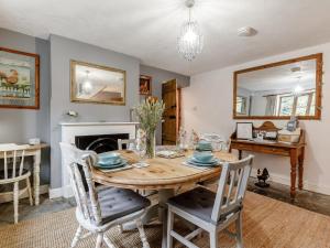 a dining room with a wooden table and chairs at The Cottage in Wells