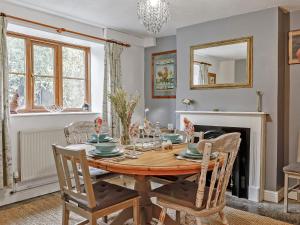 a dining room with a wooden table and chairs at The Cottage in Wells