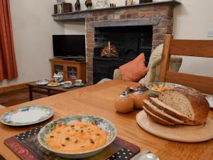 a table with bowls of soup and bread on it at Elidir Cottage in Llanwnda