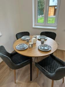 Una mesa de madera con cuatro sillas alrededor. en Vila Fráňa apartmán 5, en České Budějovice