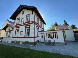 a large white house with a patio in front of it at Vila Fráňa apartmán 5 in České Budějovice