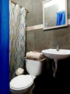 a bathroom with a toilet and a sink at Casa Mafer Lodge in Montañita