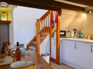 a kitchen with a table with a microwave and a staircase at Rock Cottage in Saint Abbs