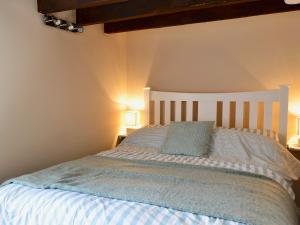a bedroom with a large bed with two lamps at Rock Cottage in Saint Abbs +4 photos