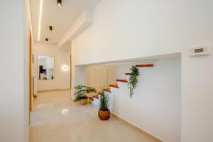 a hallway with plants and stairs in a building at Oasis Acropolis Serres With Parking Next to Center in Serres