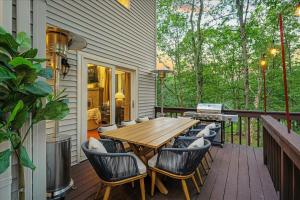 a deck with a wooden table and chairs at Sleeps 14 Hot Tub Paddle Boards Arcade Games in East Stroudsburg
