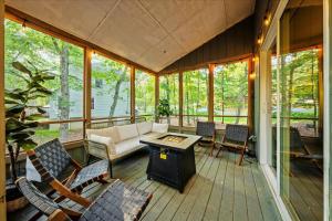 a screened in porch with a couch and chairs at Sleeps 14 Hot Tub Paddle Boards Arcade Games in East Stroudsburg