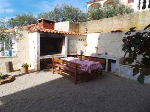 einem Tisch und einer Bank vor einem Gebäude in der Unterkunft Apartment Kornic 3 in Kornić