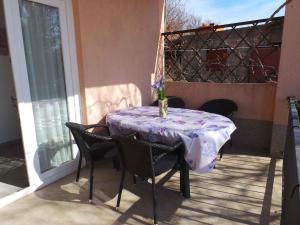 einen Tisch auf einem Balkon mit einer Blumenvase darauf in der Unterkunft Apartment Kornic 3 in Kornić