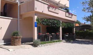 ein Gebäude mit Tischen und Blumen davor in der Unterkunft Apartment Kornic 3 in Kornić