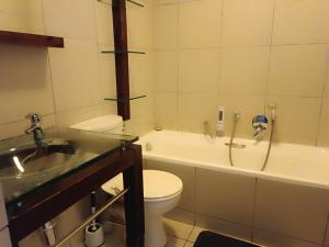 a bathroom with a toilet and a tub and a sink at Malaika Luxurious Crib, Jackal Creek Golf Estate, Northriding in Roodepoort +23 photos