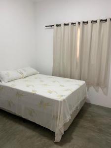 a bed in a room with a curtain at Casa Pôr do Sol in Guriú +5 photos