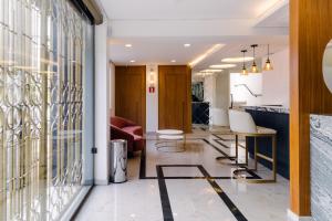 an office lobby with a desk and chairs at Hotel VARSÓVIA EXPRESS in Londrina
