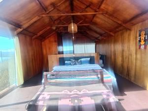 une chambre avec un lit dans une pièce en bois dans l'établissement Titicaca puma, à Puno